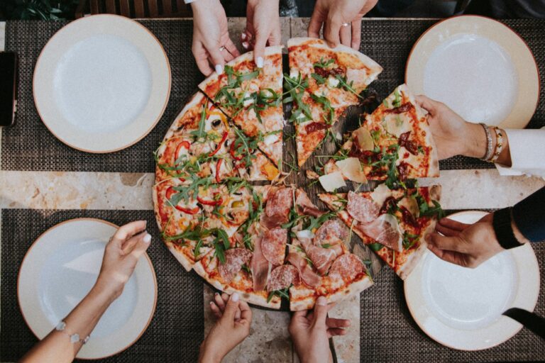 Persone che prendono un pezzo di pizza